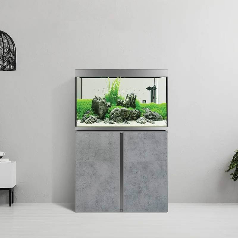 Fluval Siena 272L Aquarium Set with rocks, plants, canister filter, on gray cabinet.