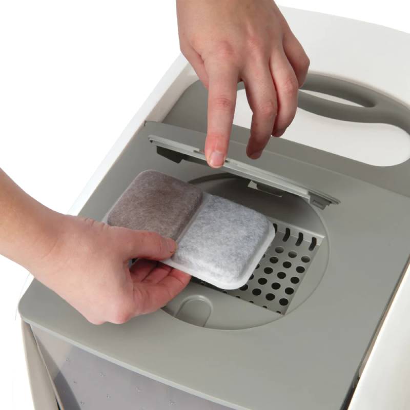 Inserting a Catit Airsift Dual Action Pad 2pk into an air purifier to help reduce odours.