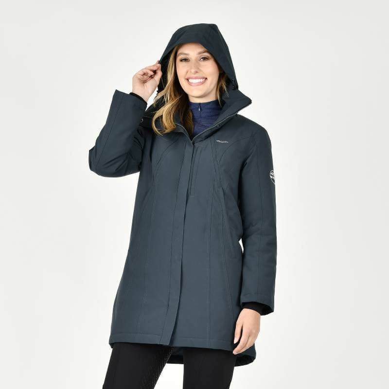 Woman smiles in a Weatherbeeta Kyla Waterproof Jacket Pine by Weatherbeeta against a white backdrop.