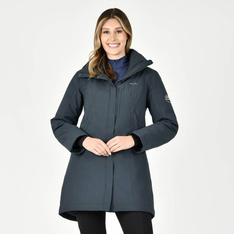 Woman in a Weatherbeeta Kyla Waterproof Jacket Pine, smiling, with a plain white background.