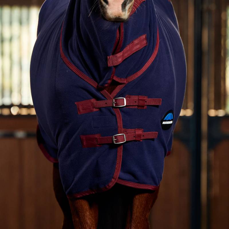 A horse in a Weatherbeeta Anti-Static Fleece Cooler Combo Neck Navy/Burgundy stands in a stable.