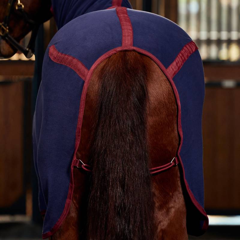 A horse wears a Weatherbeeta Anti-Static Fleece Cooler Combo Neck Navy/Burgundy in a stable.