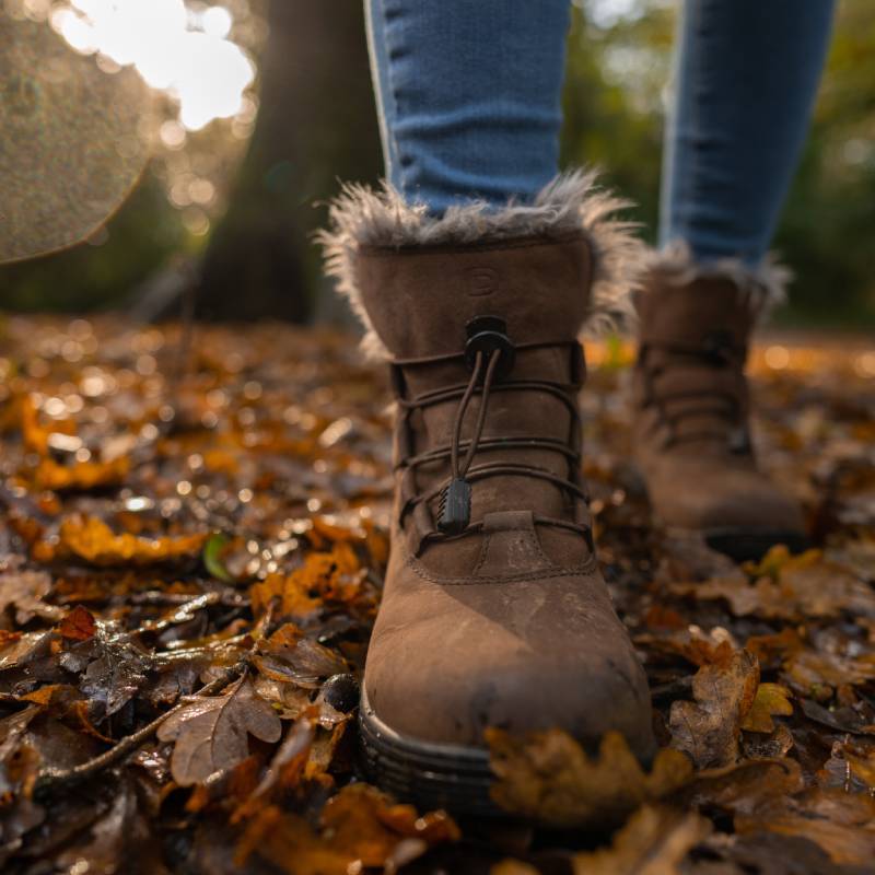 Dublin Boyne Boots Brown Adult by Dublin walking on autumn leaves, blurred trees in background.