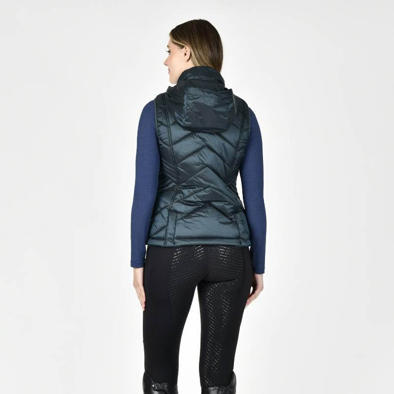 Woman wears Weatherbeeta Presley Puffer Vest Pine vest, facing away on a white background.