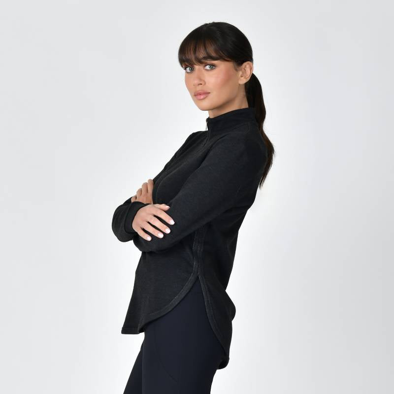Woman in Weatherbeeta London Layer Long Sleeve Top stands sideways with arms crossed.