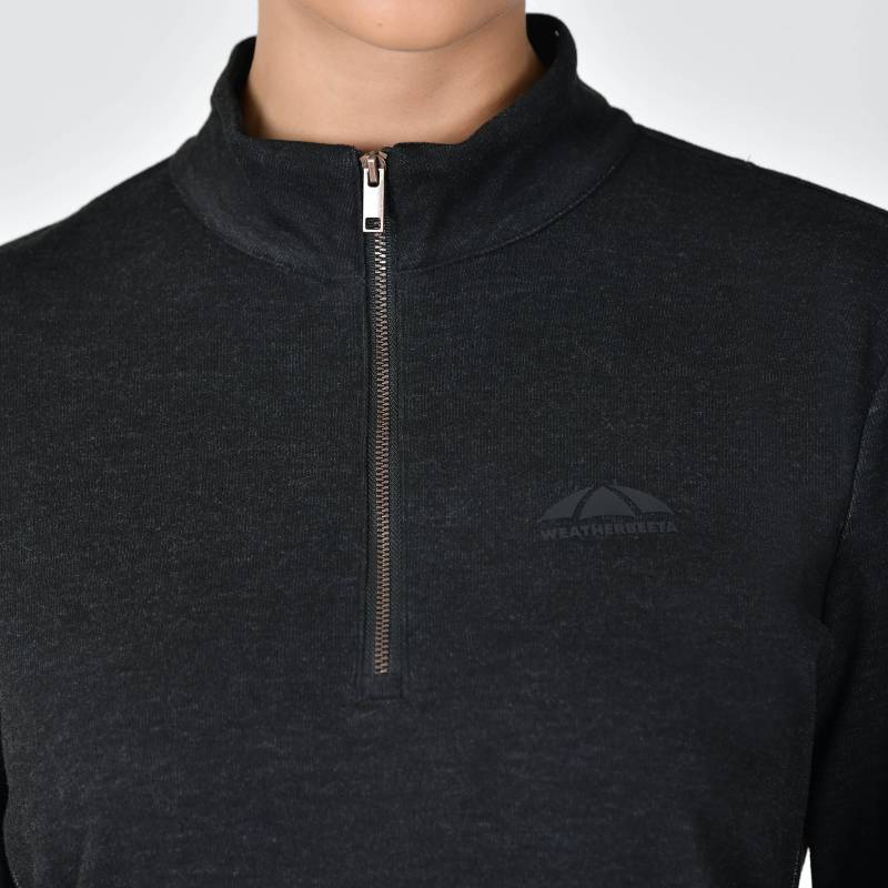 Person wearing a black Weatherbeeta London Layer Long Sleeve Top with chest logo.