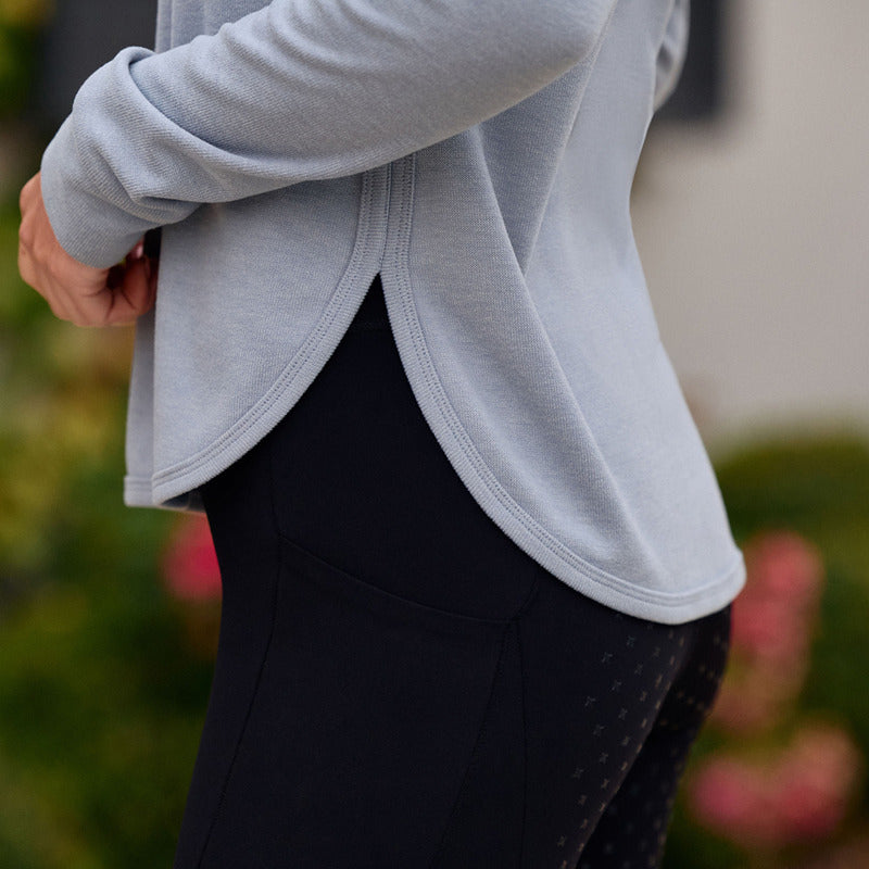 Person in a Weatherbeeta London Layer Long Sleeve Top, side view outdoors, wearing black leggings.