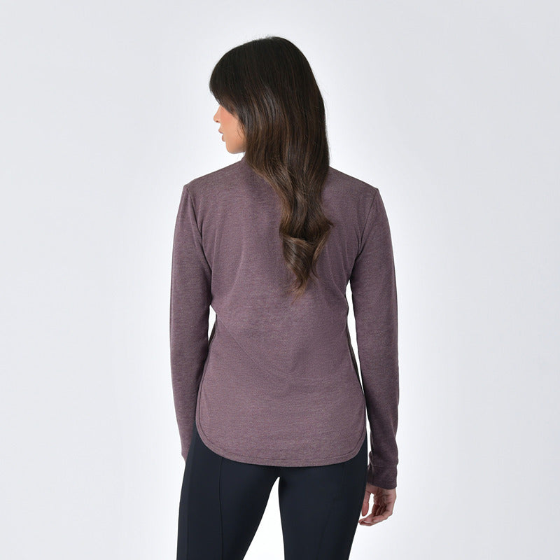 Woman in Weatherbeeta London Layer Long Sleeve Top Mulberry Marle, black leggings, white backdrop.
