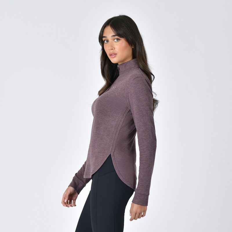 Woman in a Weatherbeeta London Layer LS Top Mulberry Marle stands sideways against white background.