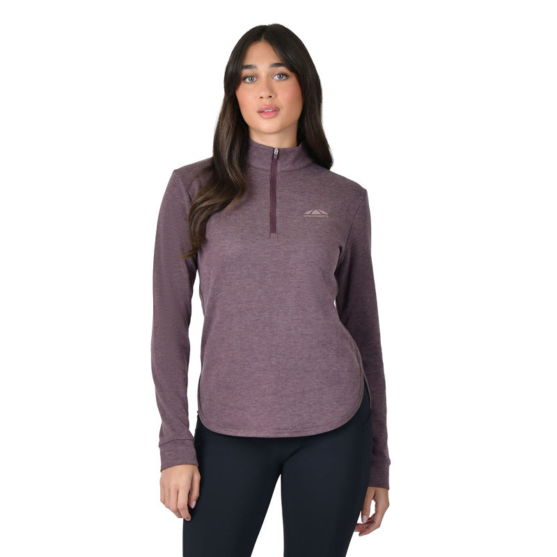 Woman in Weatherbeeta London Layer Long Sleeve Top Mulberry Marle, black leggings, white backdrop.