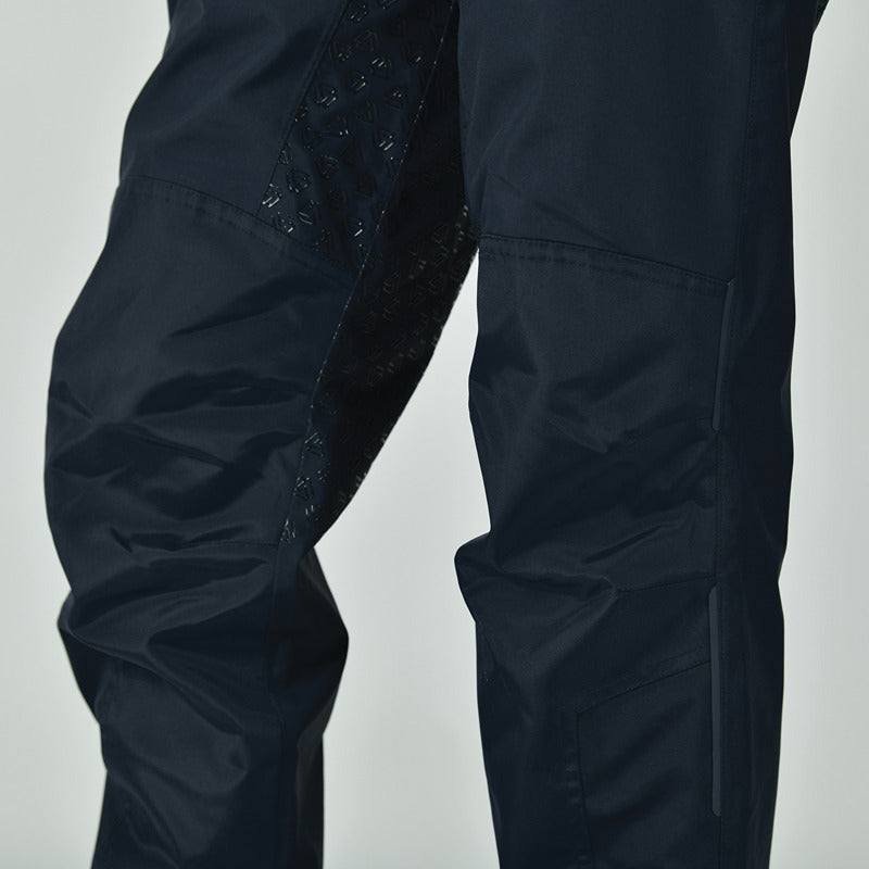 Close-up of a person wearing Weatherbeeta Rayne Waterproof Overtrousers II in Navy/White.