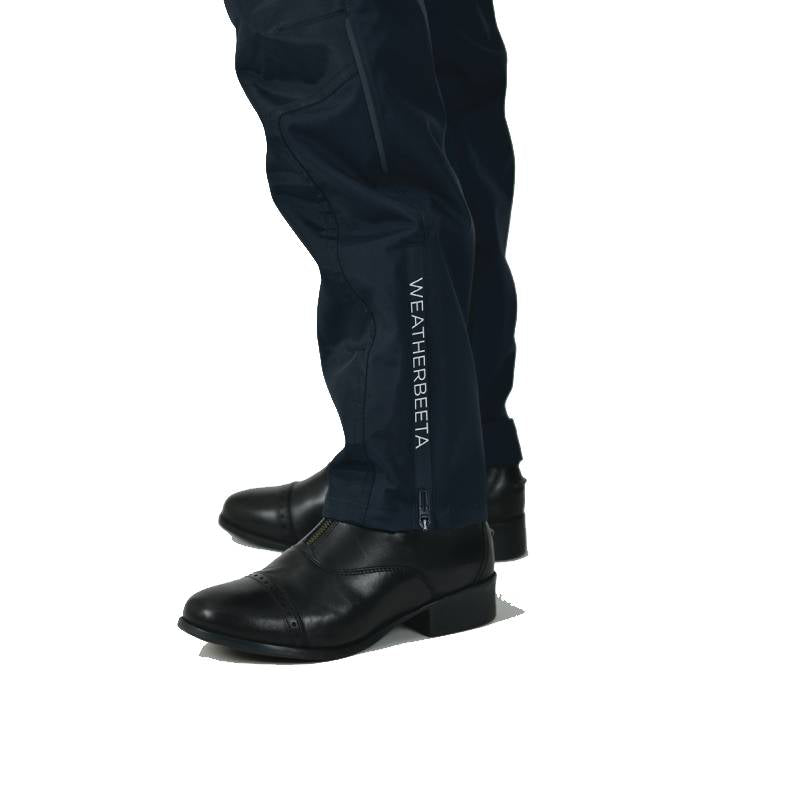 Person wearing Weatherbeeta Rayne Waterproof Overtrousers II Navy/White and black dress shoes.