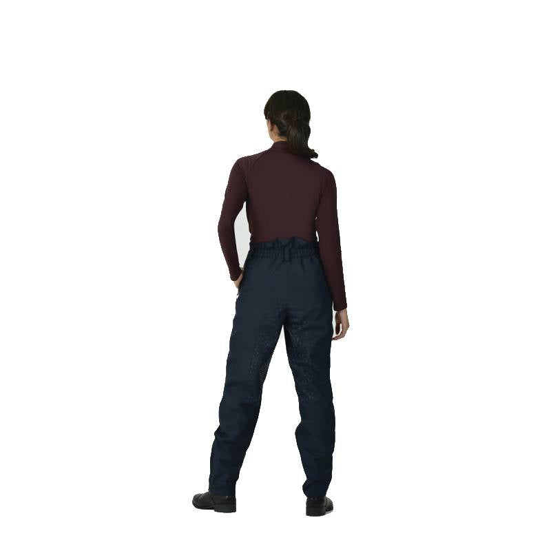 Woman in a maroon top and Weatherbeeta Rayne Waterproof Overtrousers II stands facing forward.