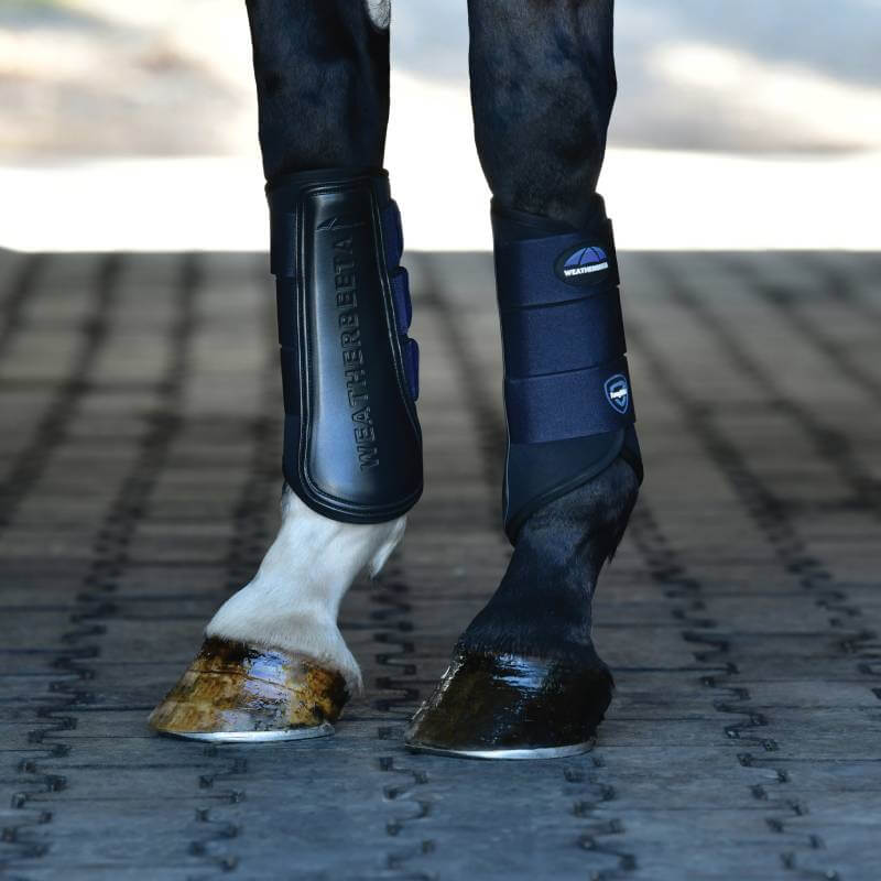 Weatherbeeta Tough-Tec Prime Brushing Boots in Black/Navy protect horse legs on rubber matting.