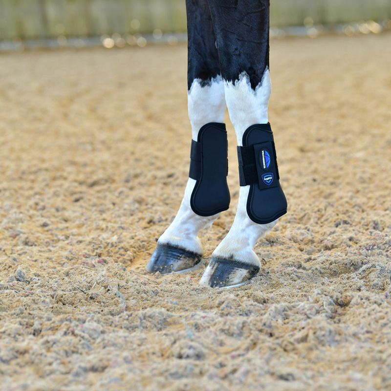 Close-up of horse legs in Weatherbeeta Tough-Tec Prime Open Front Boots Black/Black on sand.