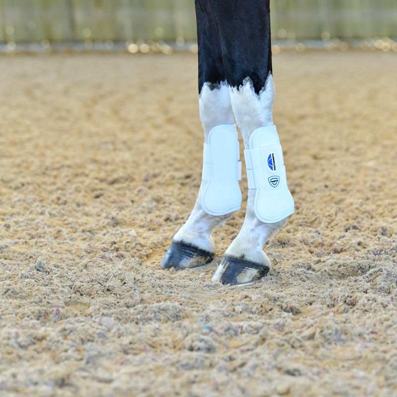 Close-up of a horse’s legs in Weatherbeeta Tough-Tec Prime Open Front Boots on sandy ground.