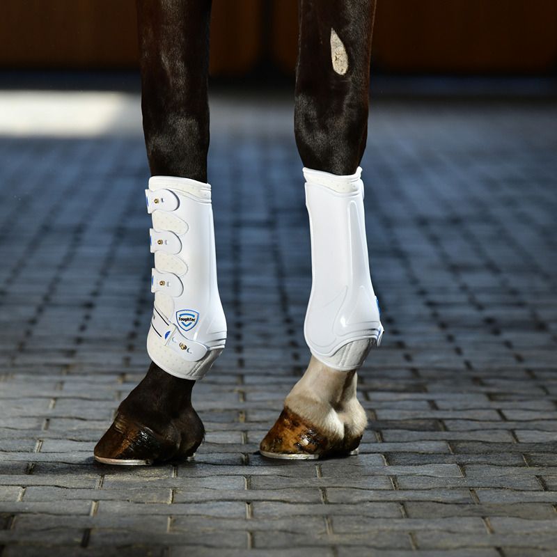 Close-up of Weatherbeeta Tough-Tec Hard Shell Dressage Boots White on horse legs on pavement.