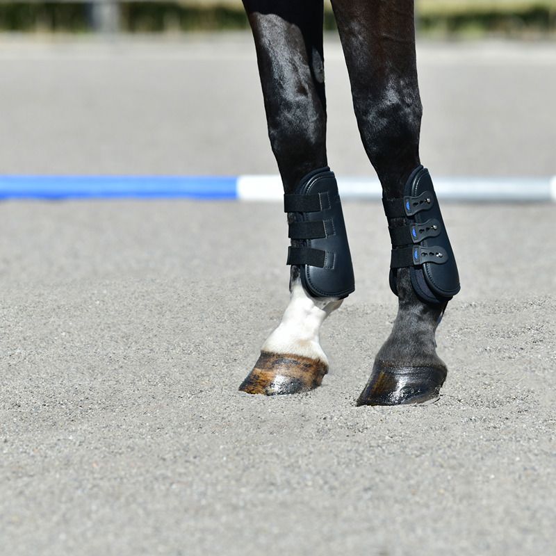 Horses' legs on sand in Weatherbeeta Tough-Tec Pro Open Front Boots Black.