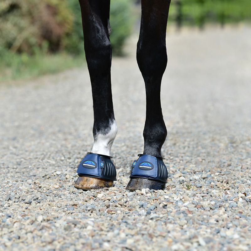 Close-up of horse legs on gravel wearing Weatherbeeta Tough-Tec Prime Rubber Bell Boots.