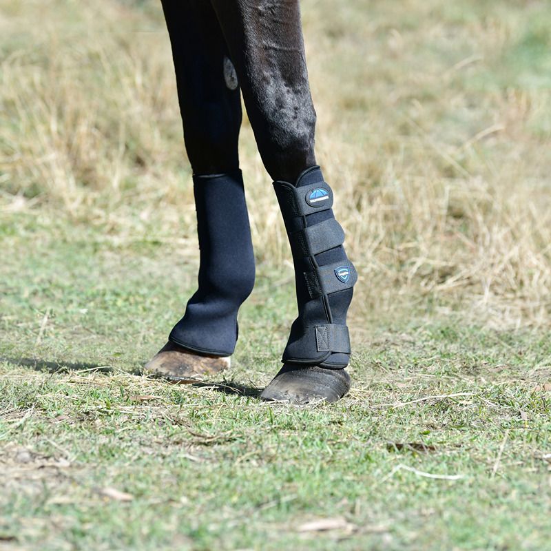 Close-up of a horse's legs wearing Weatherbeeta Tough-Tec Turnout Boots Black on grass.