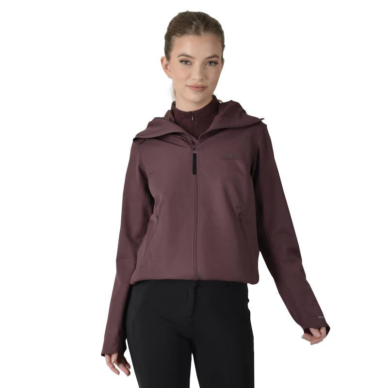 Woman in a Weatherbeeta Abrasion Proof Stretch Riding Jacket Mulberry, black pants, white backdrop.
