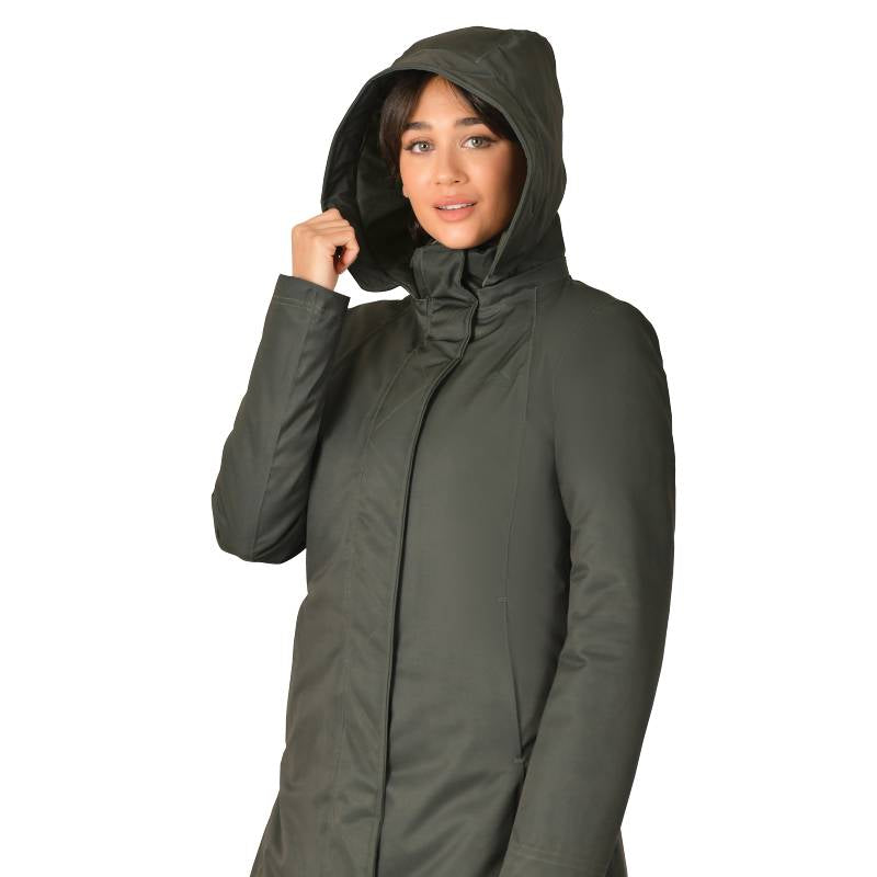 Woman in a Weatherbeeta Midnight Green Longline Waterproof Jacket looks at camera, holding hood.