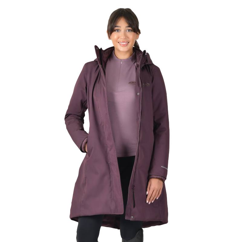 Woman wears Weatherbeeta All Purpose Waterproof Longline Equestrian Jacket in Mulberry, smiling.