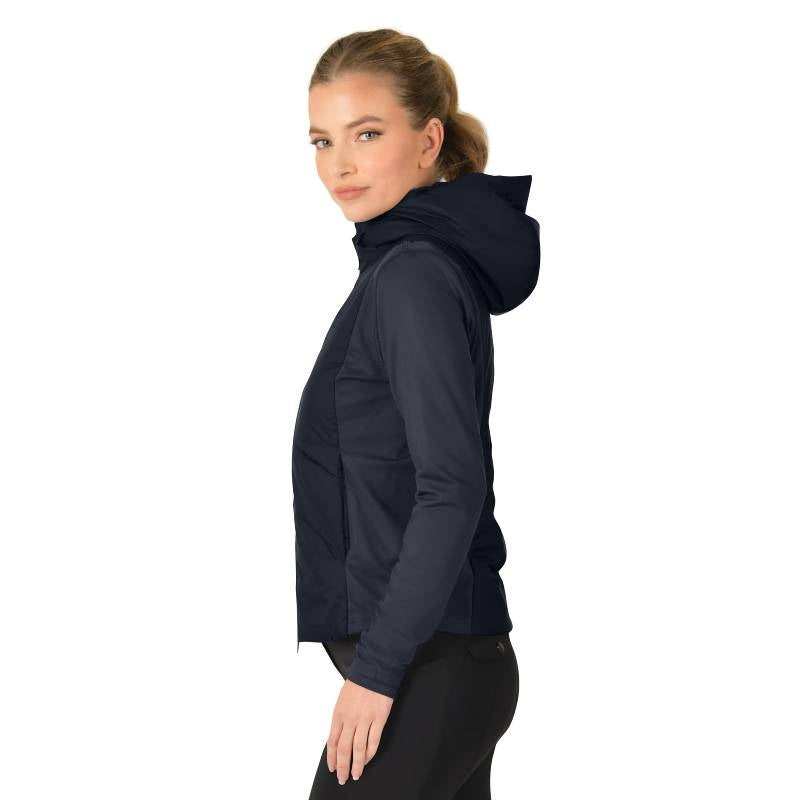 Woman in a Weatherbeeta Hybrid Padded Jacket Navy and black leggings stands sideways on white.