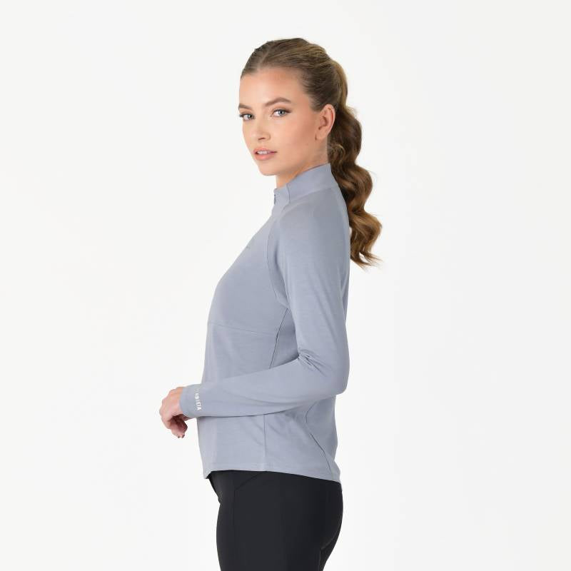 Woman in Weatherbeeta Bamboo Long Sleeve Performance Base Layer Bluestone and black leggings.