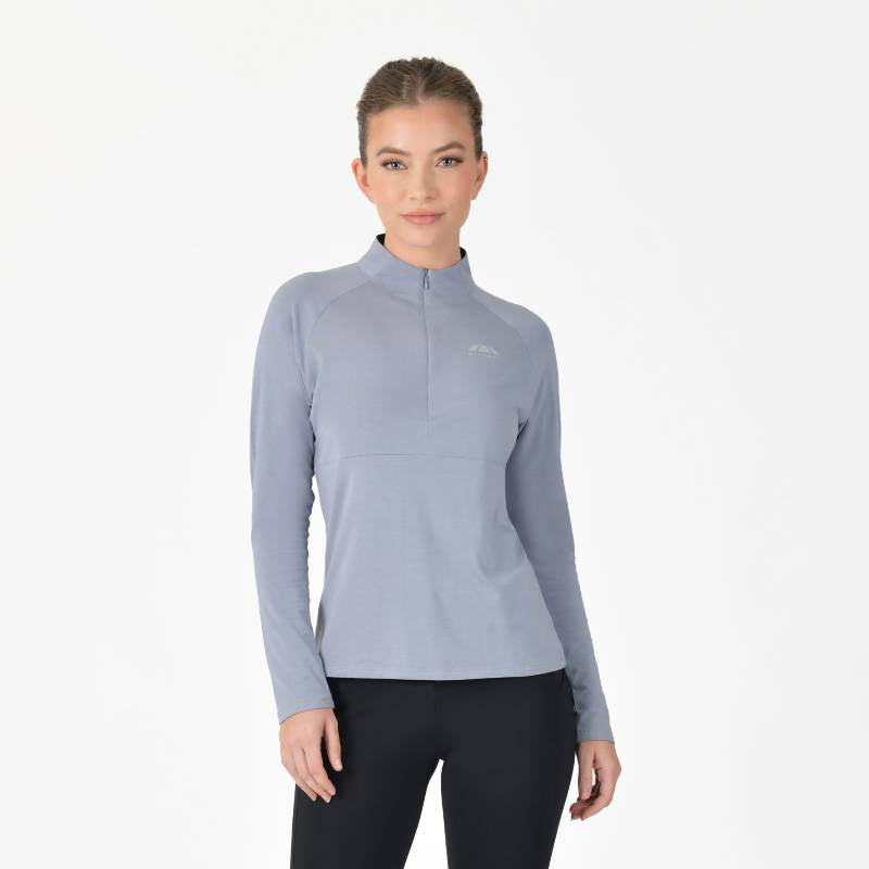 Woman in a Weatherbeeta Bamboo Long Sleeve Base Layer Bluestone and black pants, white background.