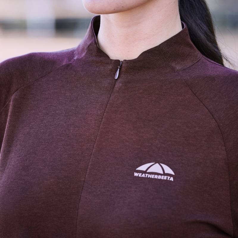 Woman in Weatherbeeta Bamboo Long Sleeve Base Layer Mulberry, logo on chest.