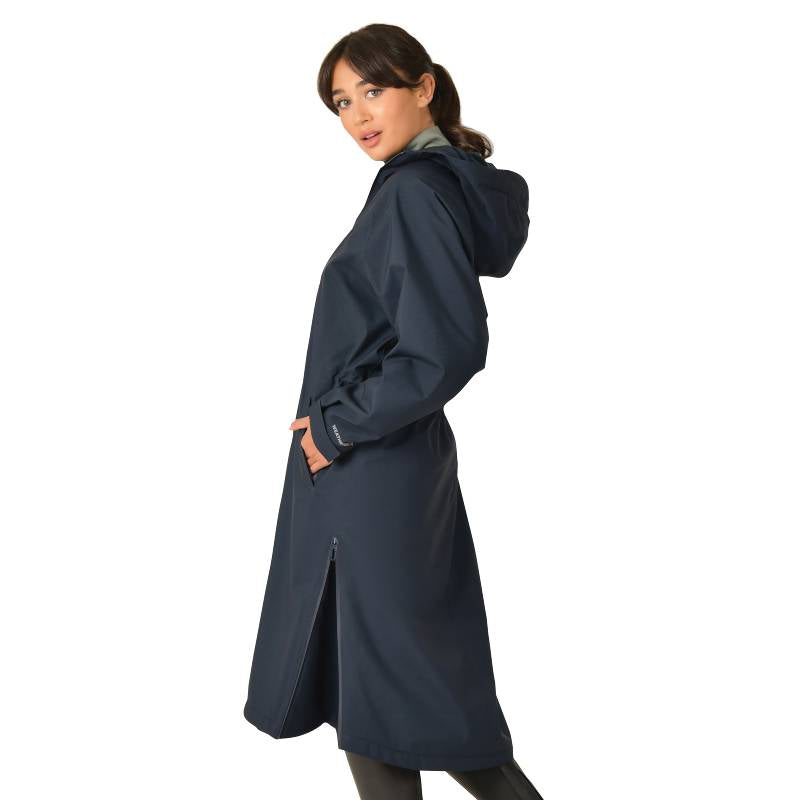 Woman in Weatherbeeta All Weather Field Jacket Navy stands with hands in pockets, looking back.