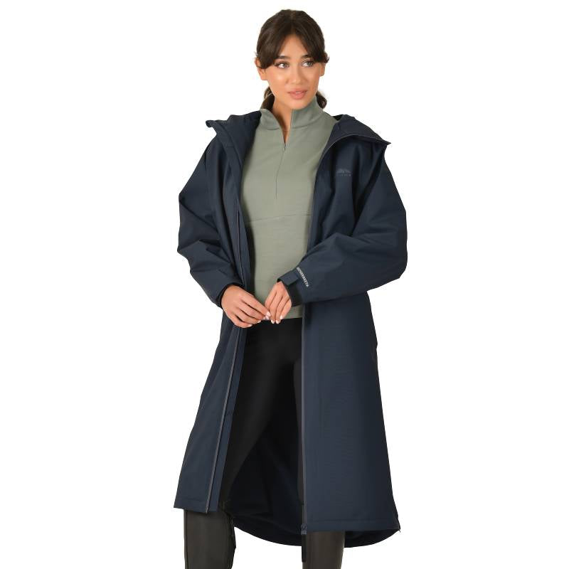 Woman in Weatherbeeta All Weather Field Jacket Navy over a light green top and black pants.