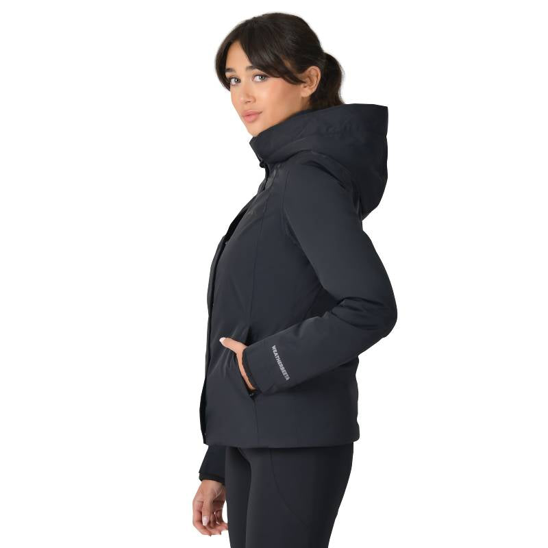 Woman in a Weatherbeeta Protect Jacket With High Neck Black, standing sideways with hands in pockets.