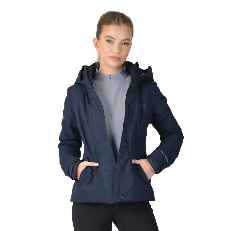Woman in a Weatherbeeta Protect Jacket With High Neck Navy over a light gray top.