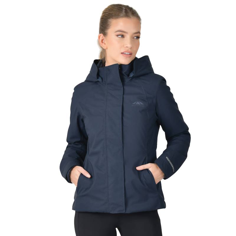 Woman in Weatherbeeta Protect Jacket With High Neck Navy, hands in pockets, facing sideways.