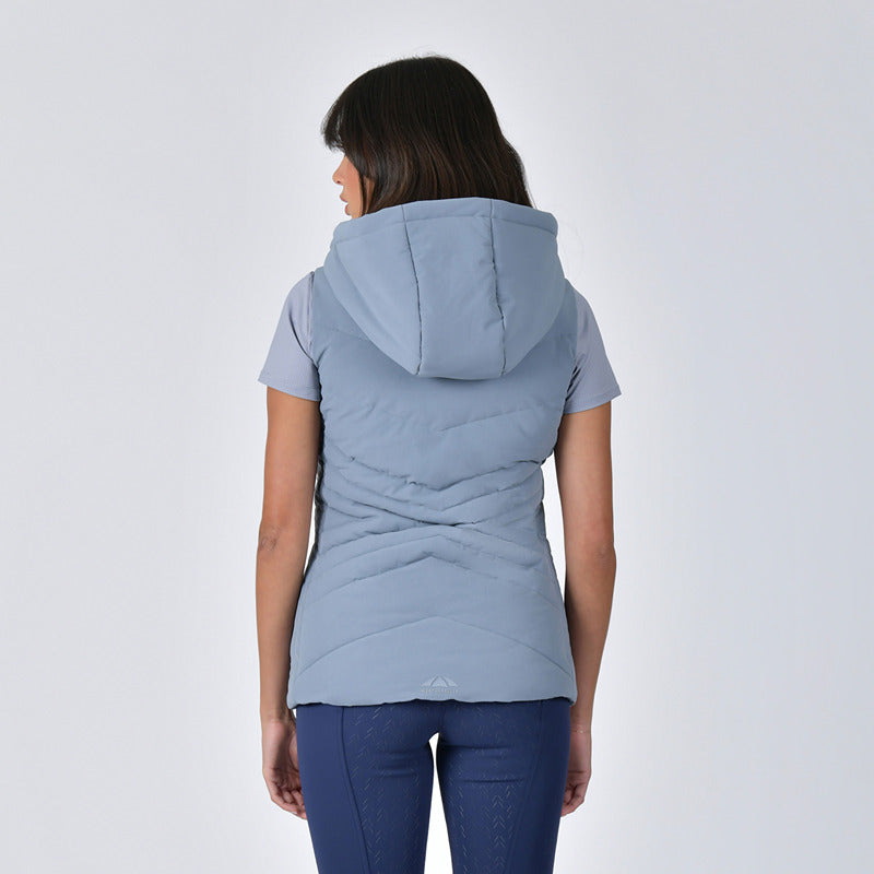 Woman wears a Weatherbeeta Insulated Vest Bluestone, short-sleeve shirt, and navy leggings.