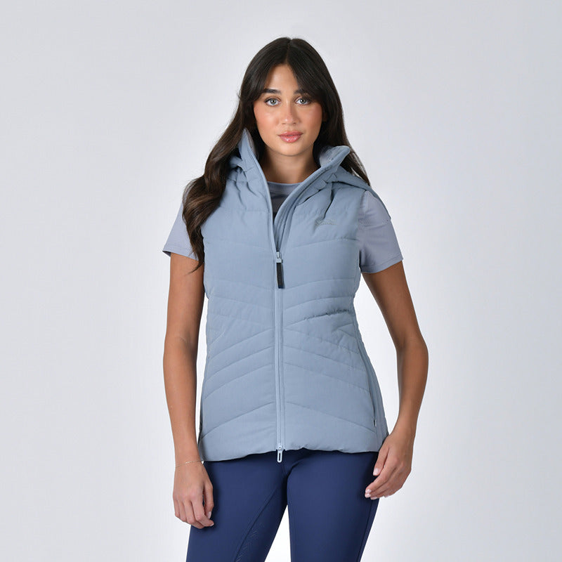 Woman wears a Weatherbeeta Insulated Vest Bluestone, short-sleeve shirt, and navy leggings.