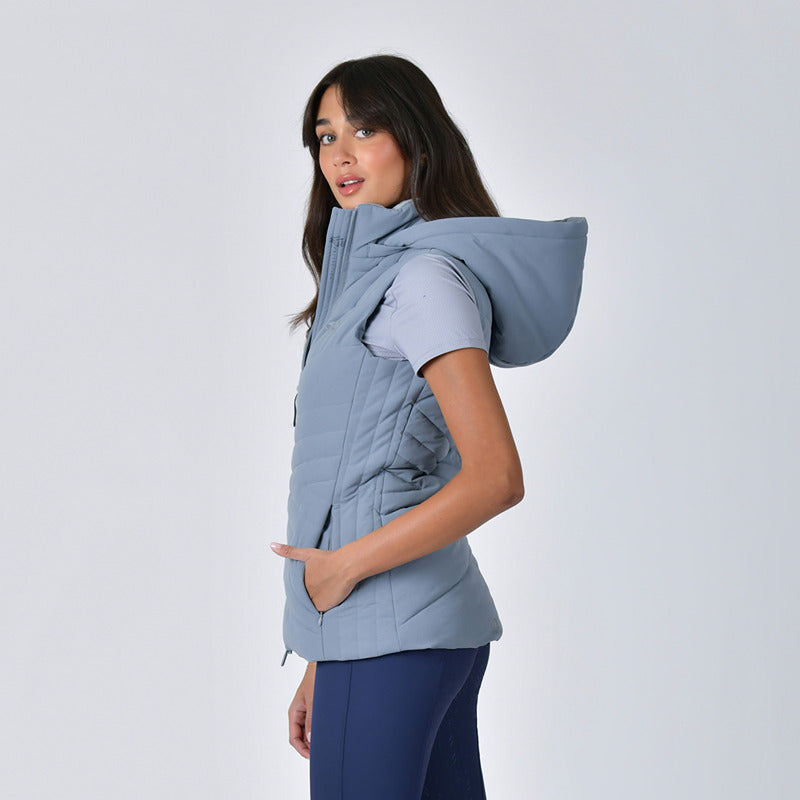 Woman models Weatherbeeta Insulated Vest Bluestone and navy leggings against a plain background.