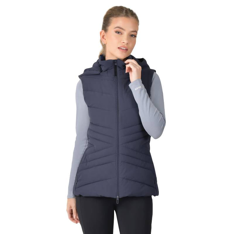 Woman in Weatherbeeta Insulated Vest Navy and gray long-sleeve shirt, standing sideways.