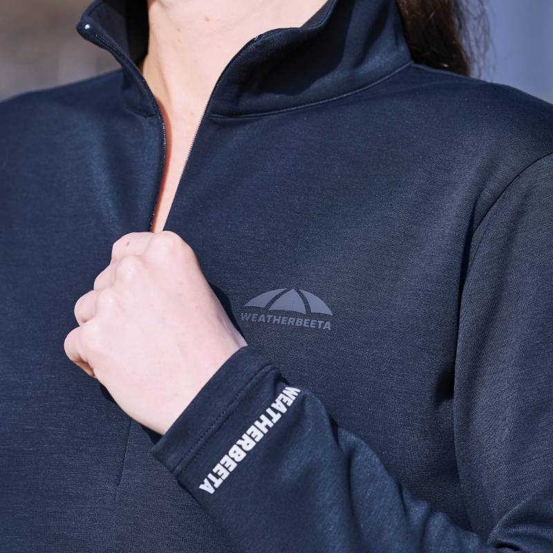 Woman wears Weatherbeeta Copper 1/2 Zip Top, holding horse in matching navy Weatherbeeta blanket.