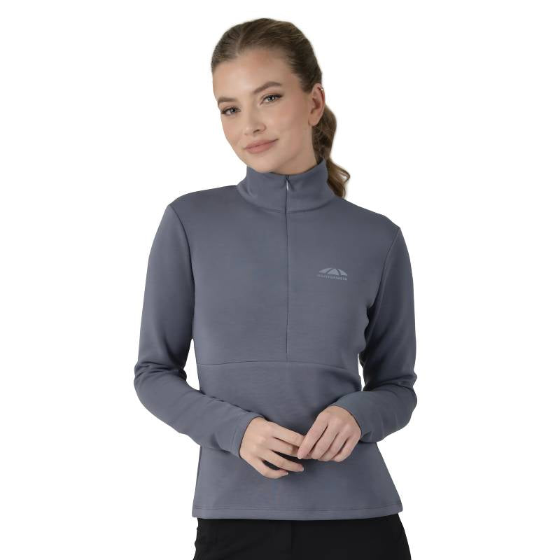 Woman in a slate blue Weatherbeeta Copper 1/2 zip mid-layer, smiling with hands clasped.