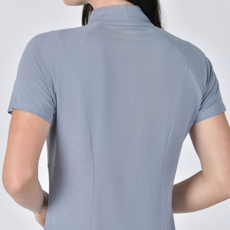 Person wearing a blue Weatherbeeta Bamboo Short Sleeve Performance Base Layer with logo on collar.