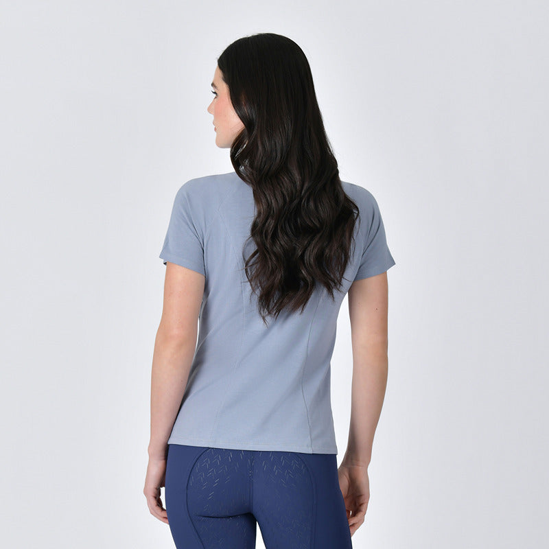 Woman wears Weatherbeeta Bamboo Blue Stone base layer and navy pants against a plain background.