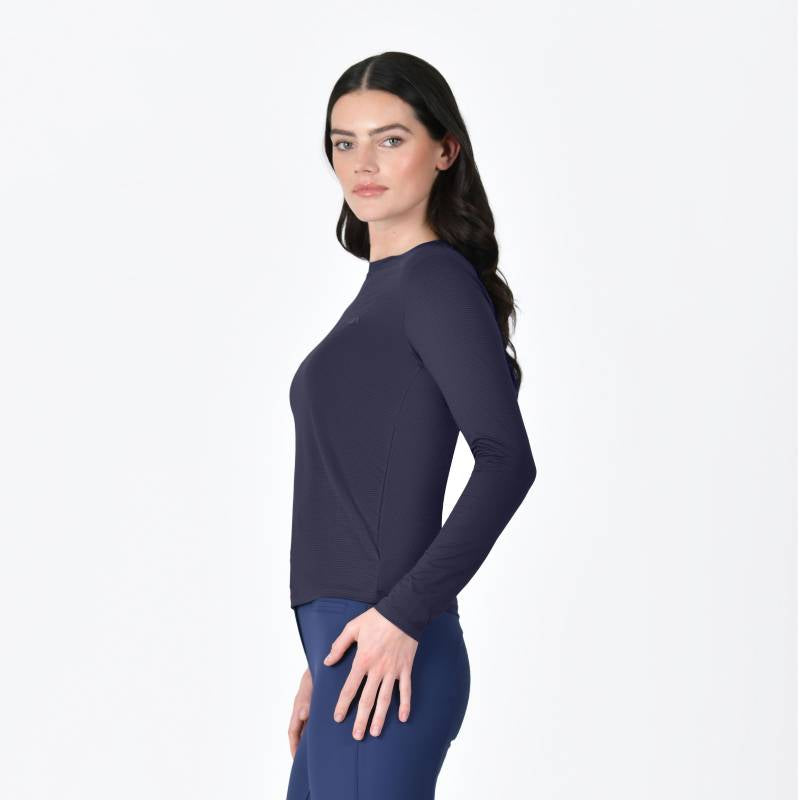 Woman with long dark hair wears Weatherbeeta Relaxed UV Long Sleeve Tee Navy and blue pants, side view.