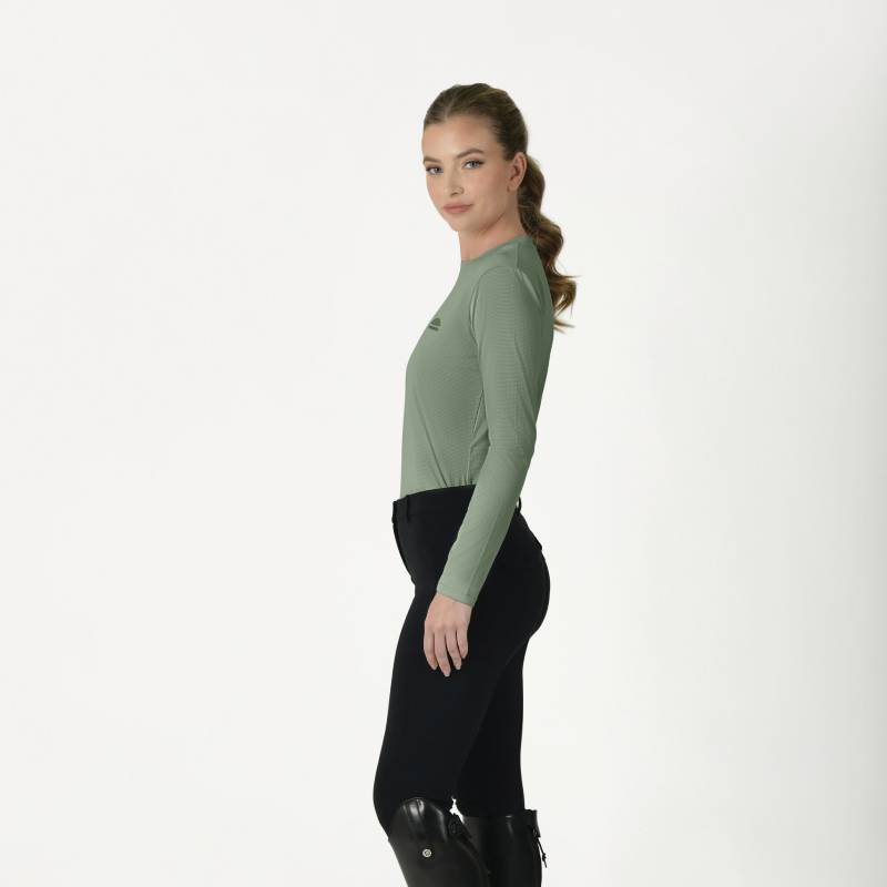 Woman in an olive Weatherbeeta Relaxed UV Long Sleeve Tee and black pants standing sideways.
