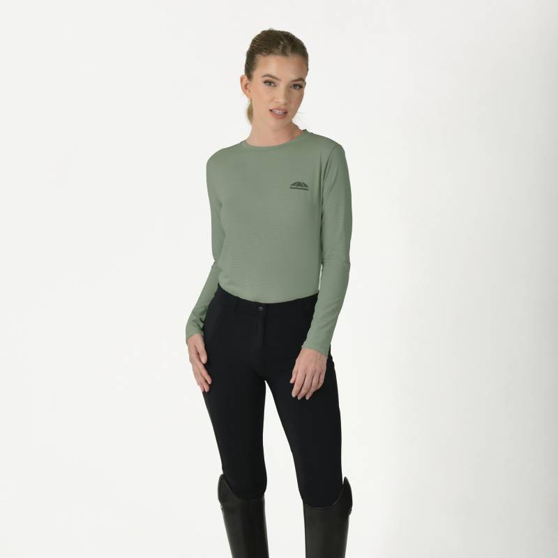 Woman in Weatherbeeta Relaxed UV Long Sleeve Tee Olive Leaf, black pants, and tall black boots.