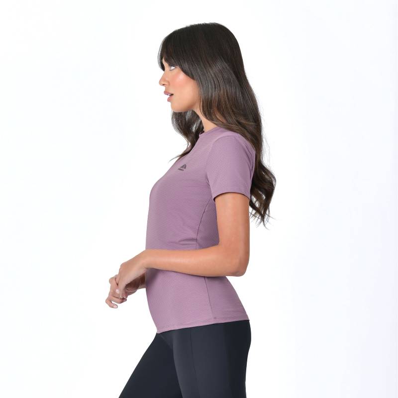 Woman wearing Weatherbeeta Relaxed UV Short Sleeve Tee in mauve wine with dark leggings, side view.