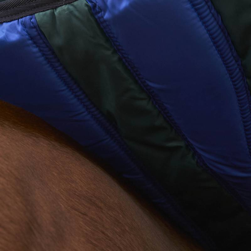 Close-up of a green Weatherbeeta Comfitec Plus Dynamic Light Weight Turnout Rug on a brown surface.