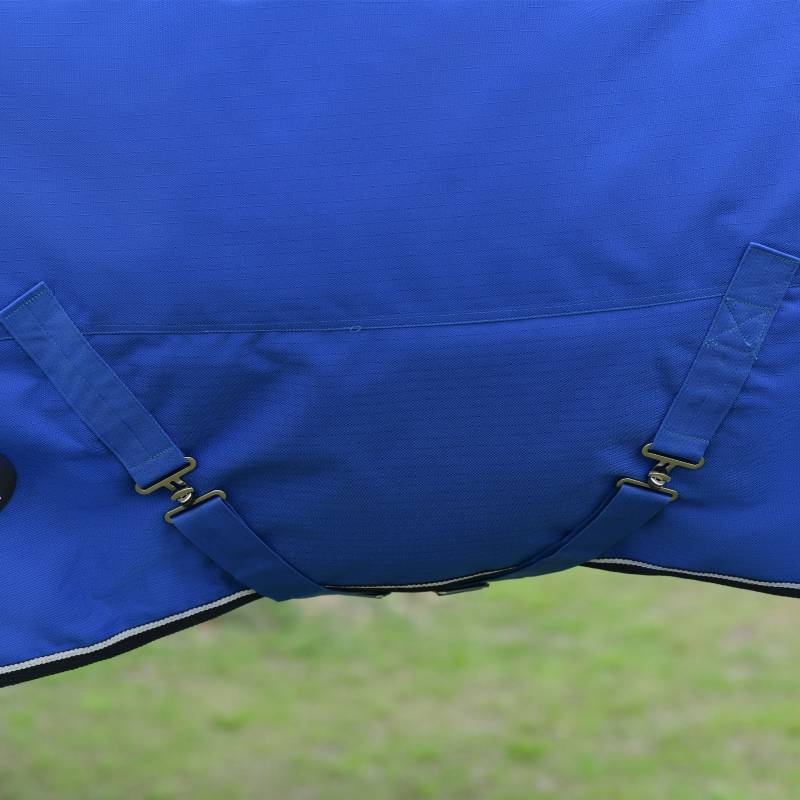 Close-up of Weatherbeeta Comfitec Essential 220g Cobalt/Black turnout rug over grass.